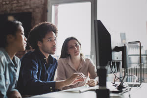 Coworkers looking at a desktop computer together