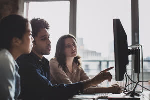 Coworkers looking at a desktop computer together