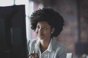 Female african american business executive working in an office on a desktop computer