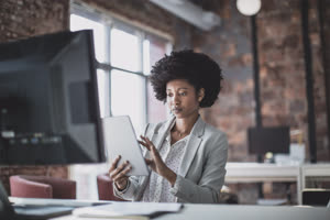 Female african american business executive working in an office on a digital tablet